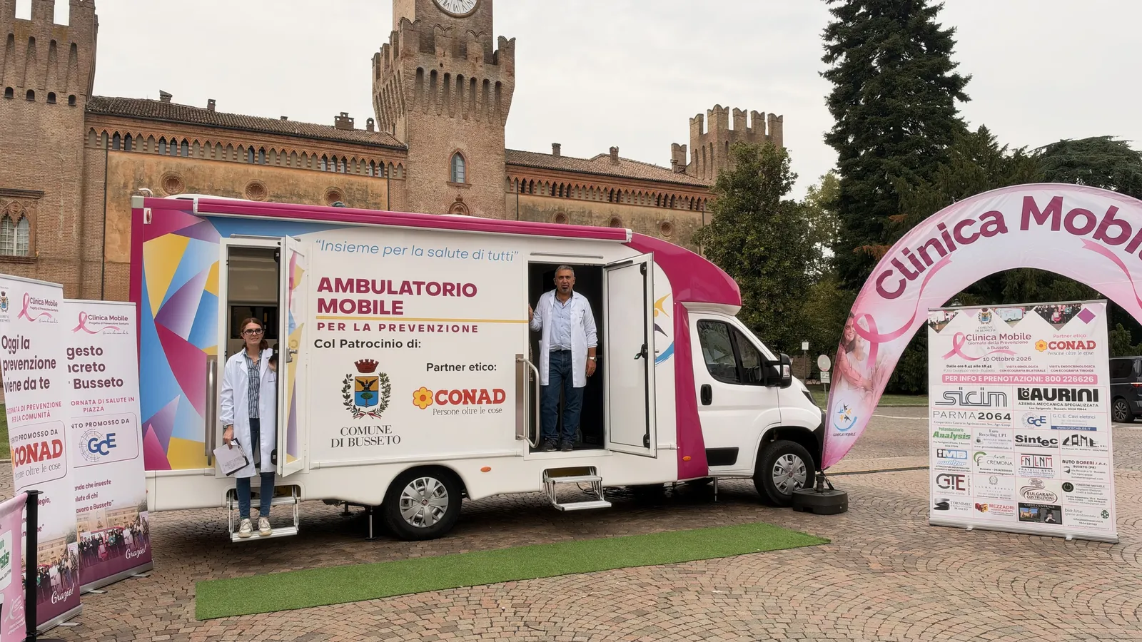 L'ambulatorio mobile con le porte aperte e l'arco rosa davanti alla Rocca di Busseto