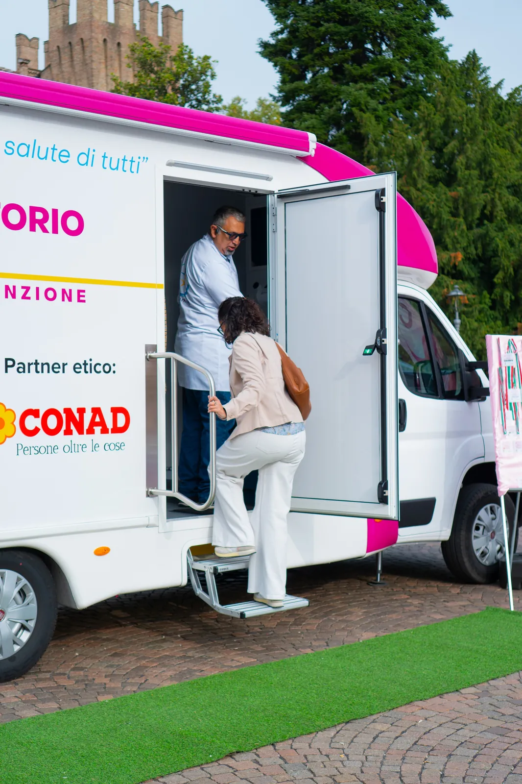 Una signora sale i gradini dell'ambulatorio mobile per l'ecografia a Busseto