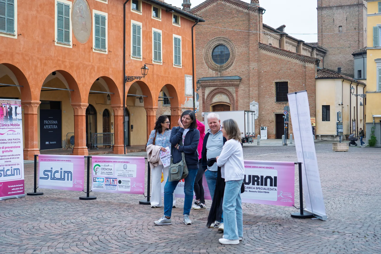 Persone in attesa del turno sotto i portici di Piazza Verdi a Busseto