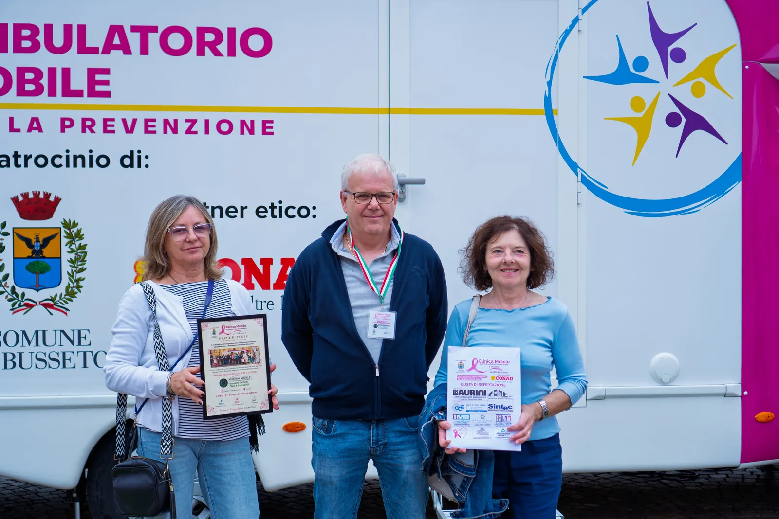 Tre partecipanti mostrano l'attestato della giornata di prevenzione a Busseto