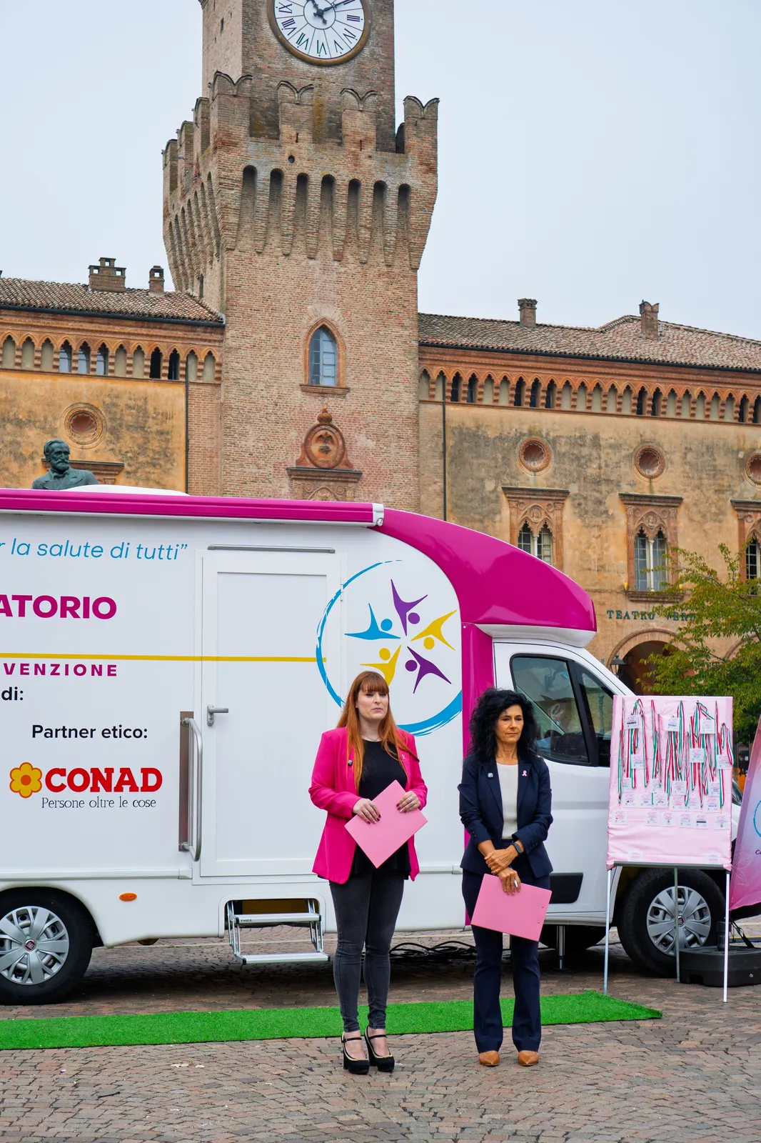 Due operatrici davanti all'ambulatorio mobile sotto la torre di Busseto
