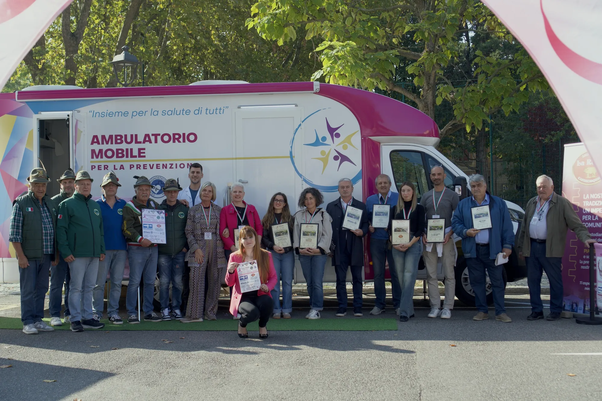 Foto di gruppo con gli attestati davanti all'ambulatorio mobile in Piazza San Carlo a Castell'Arquato