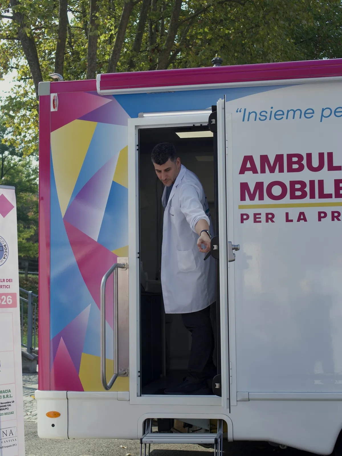 Il medico in camice sulla porta dell'ambulatorio mobile invita a salire a Castell'Arquato