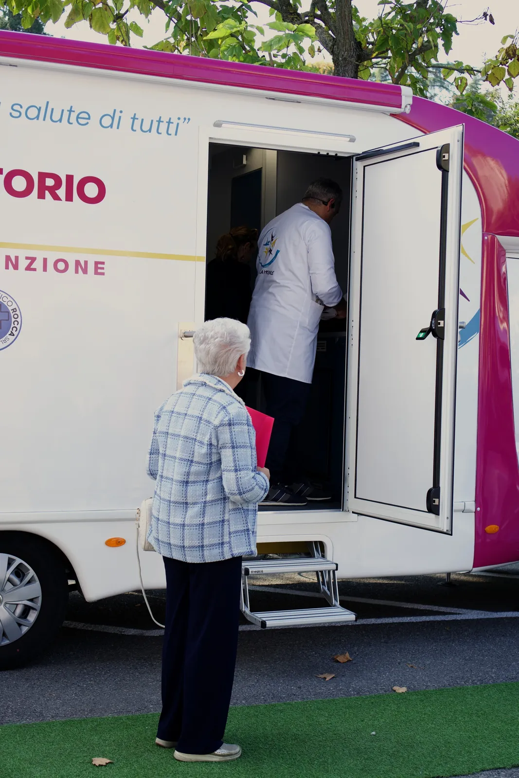 Una signora sale sull'ambulatorio mobile, il medico la aspetta dentro