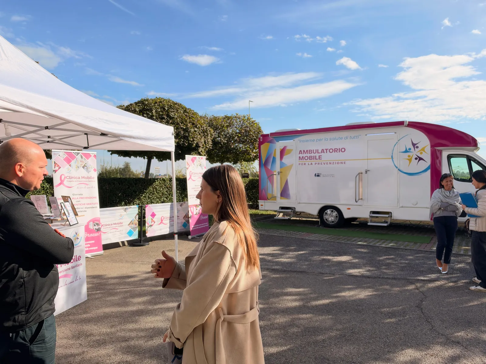 Dipendenti di FM in attesa fra il gazebo e l'ambulatorio mobile nel piazzale