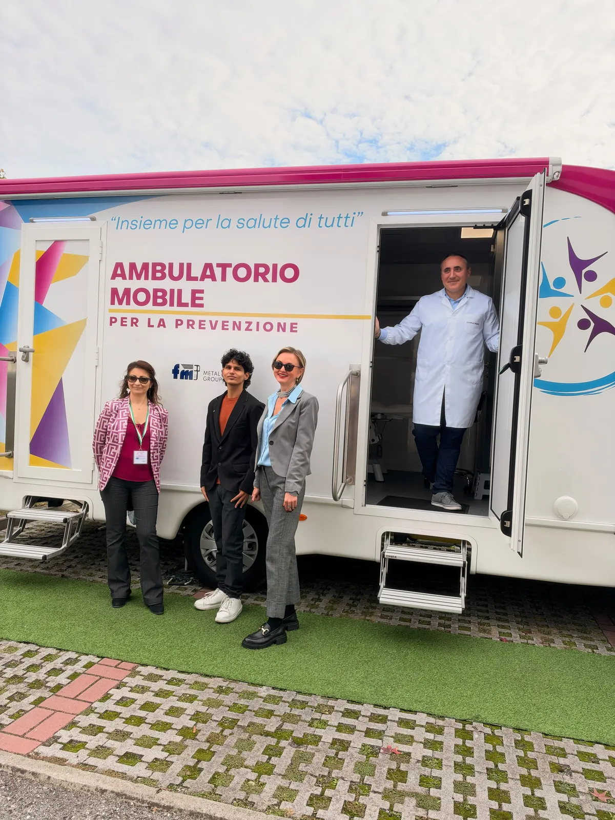 Colleghe di FM e il medico sulla porta dell'ambulatorio mobile di Clinica Mobile