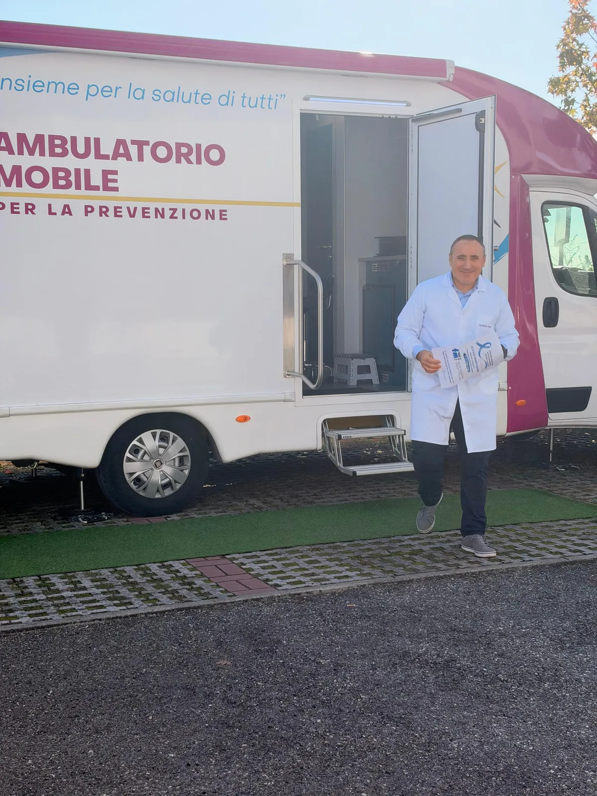 Il medico in camice esce dall'ambulatorio mobile di Clinica Mobile nel piazzale di FM