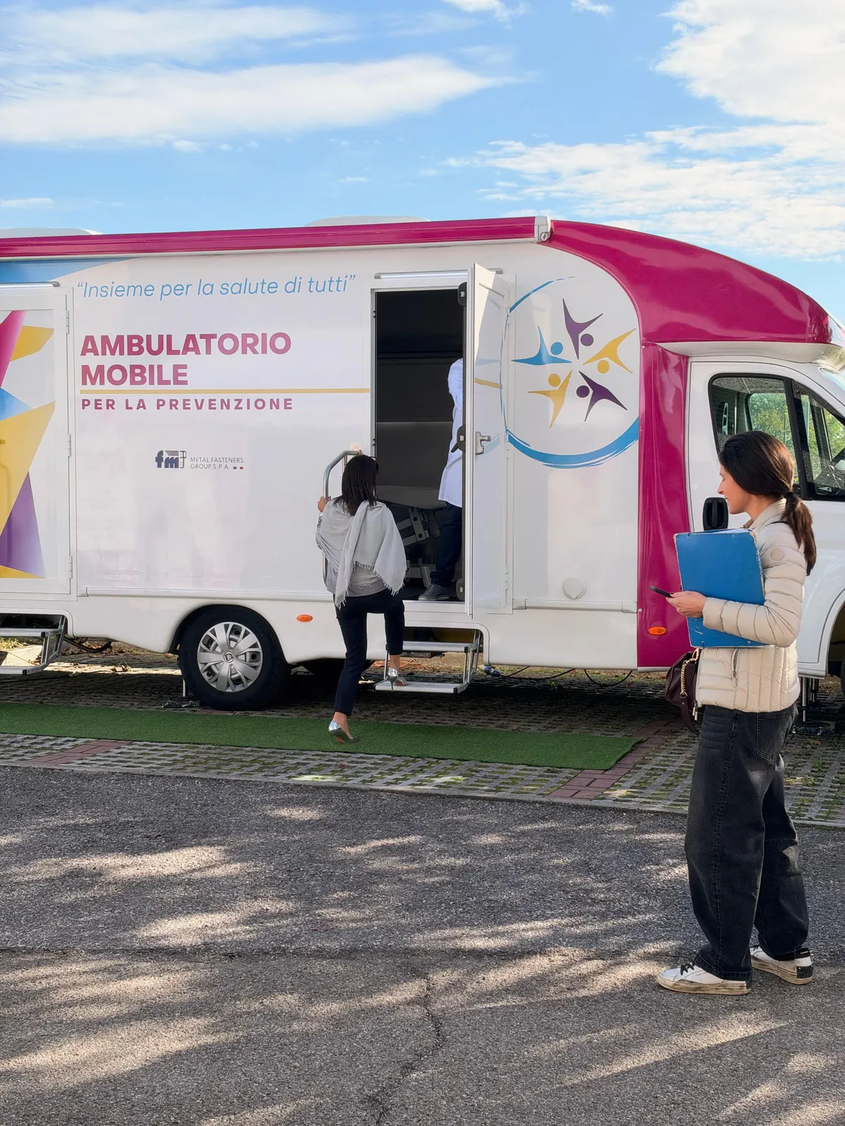 Una dipendente di FM sale i gradini dell'ambulatorio mobile