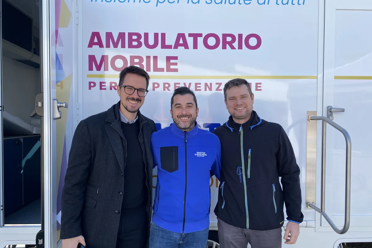Referenti di Master Builders Solutions davanti all'ambulatorio mobile della Clinica Mobile