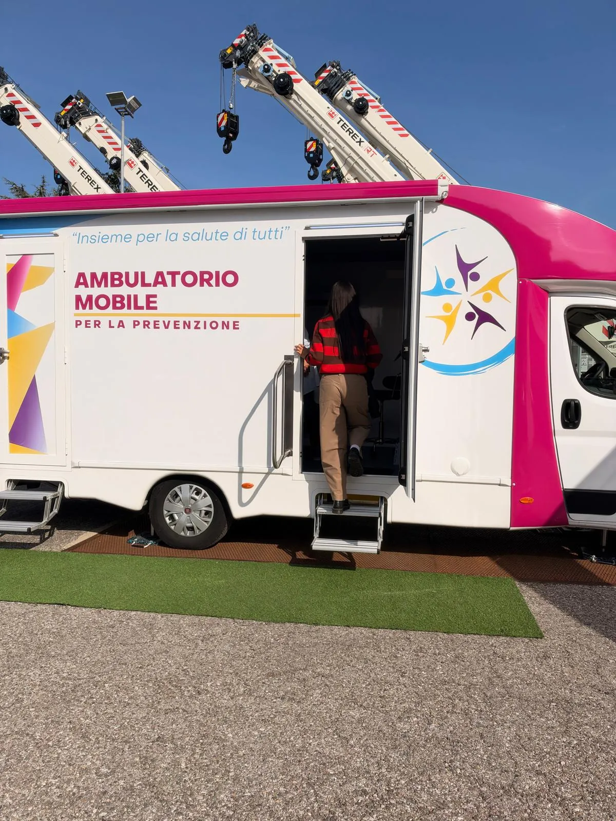 Una dipendente di RT Cranes sulla porta dell'ambulatorio mobile sotto le gru
