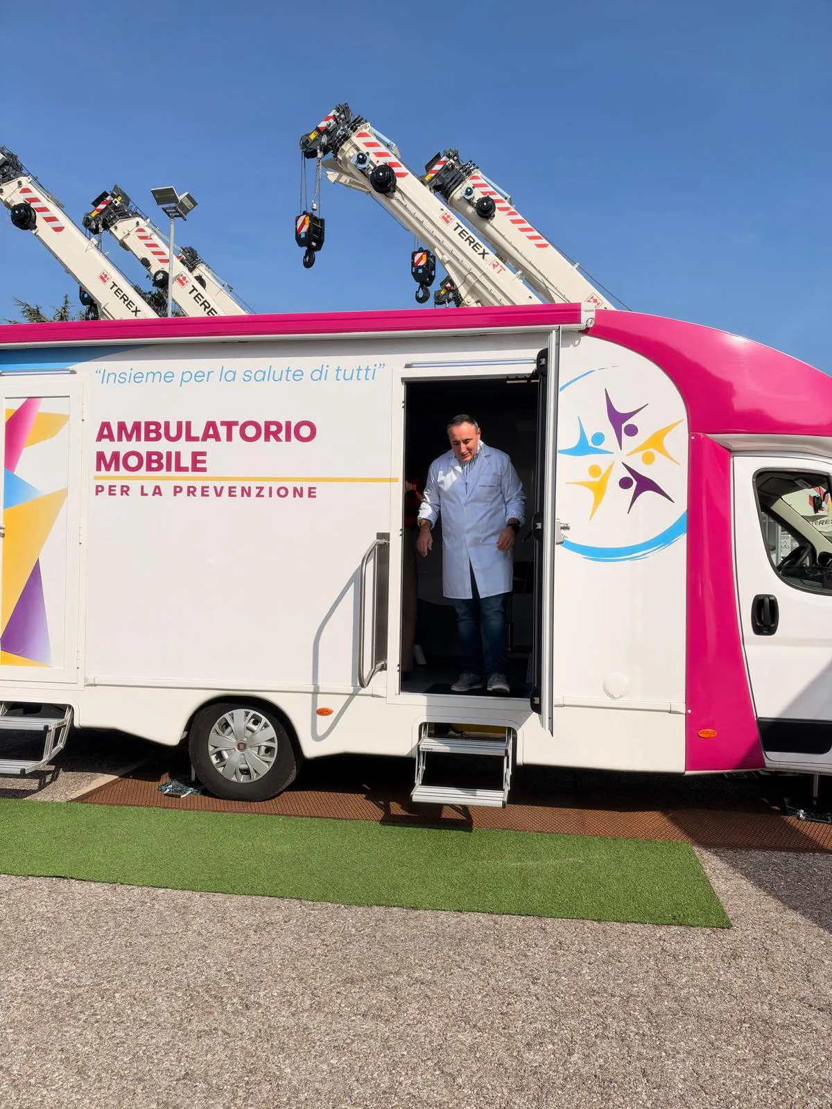 Un collaboratore sulla porta dell'ambulatorio mobile di Clinica Mobile nel piazzale di RT Cranes
