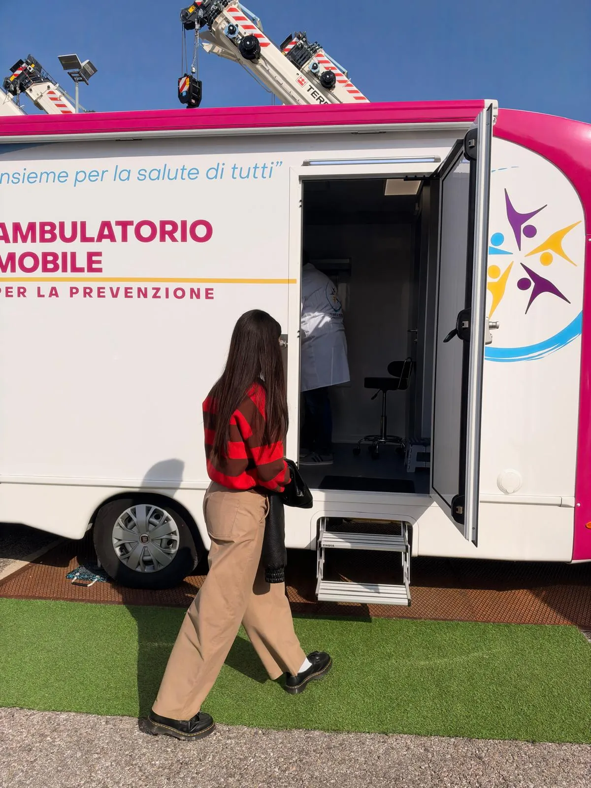 Una dipendente di RT Cranes si avvia verso la porta aperta dell'ambulatorio mobile