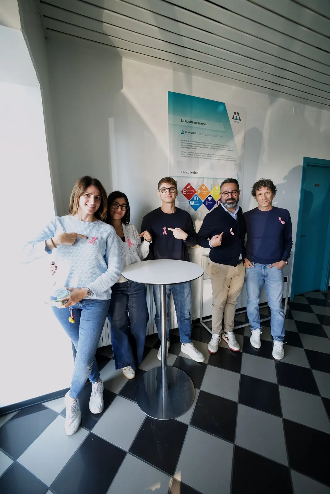 Un gruppo di colleghe e colleghi di Wittur con il fiocco rosa sul petto