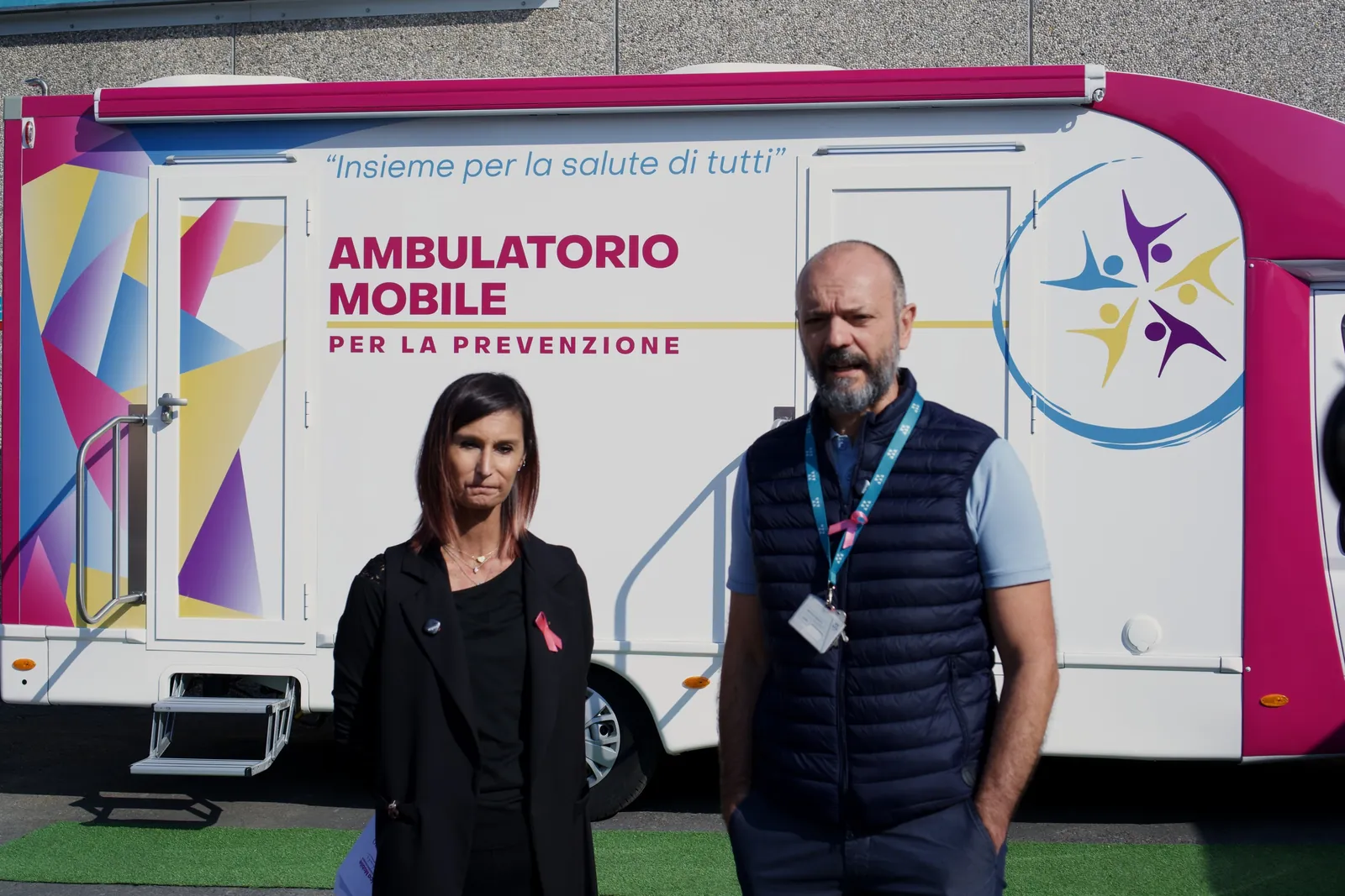 Una dipendente e un dipendente di Wittur con il fiocco rosa davanti all'ambulatorio mobile