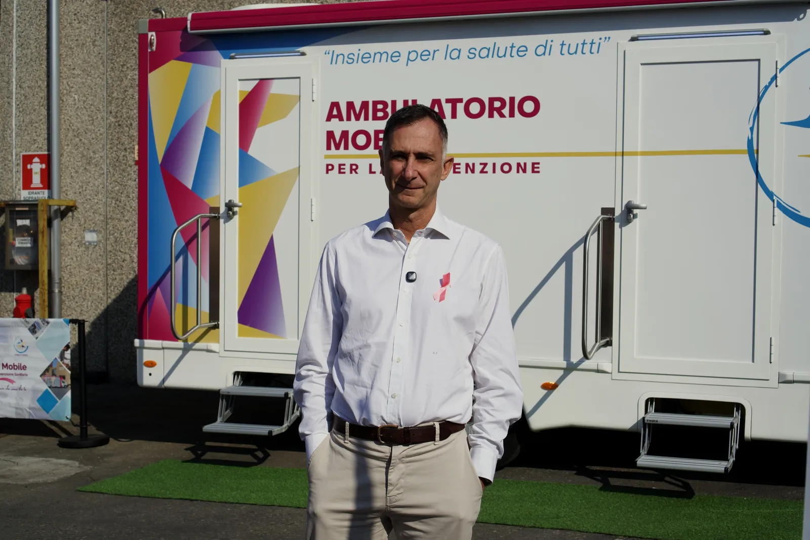 Un dipendente di Wittur in camicia bianca con il fiocco rosa davanti all'ambulatorio